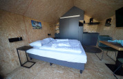 Chambre de lodge moderne avec lit double, kitchenette et coin repas à Solo Retreat 2, Zuiderzee, Pays-Bas.