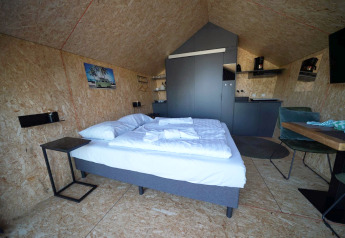 Moderne lodge med dobbeltseng, køkken og spiseplads i Solo Retreat 2 ved Zuiderzee, Holland.
