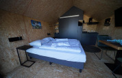 Moderne lodge med dobbeltseng, køkken og spiseplads i Solo Retreat 2 ved Zuiderzee, Holland.