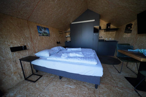 Gemütliche Lodge mit Doppelbett, Küchenzeile und Essbereich im Solo Retreat 2 bei Zuiderzee, Niederlande.