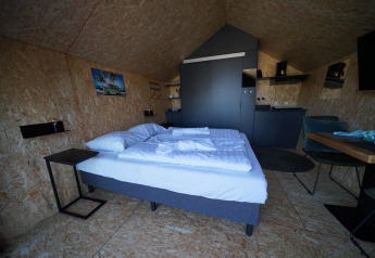 Moderne lodge met dubbel bed, keukenhoek en eethoek in Solo Retreat 2, Zuiderzee, Nederland.