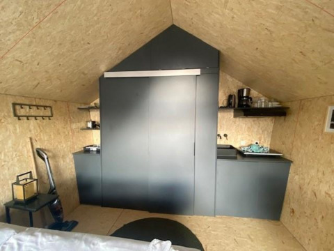 Moderne kitchenette in Solo Retreat 2 bij Zuiderzee lodge in Nederland, met strakke zwarte kasten.