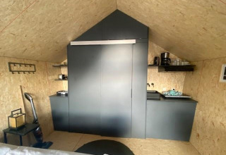 Moderne kitchenette in Solo Retreat 2 bij Zuiderzee lodge in Nederland, met strakke zwarte kasten.