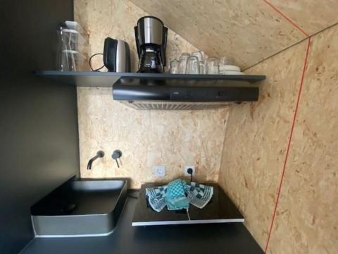 Kleine moderne kitchenette bij Solo Retreat 2 aan Zuiderzee, Nederland, met koffiezetapparaat en gootsteen.