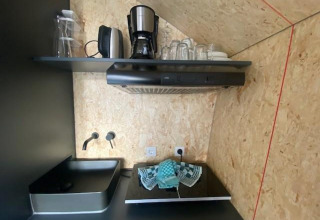 Kleine moderne kitchenette bij Solo Retreat 2 aan Zuiderzee, Nederland, met koffiezetapparaat en gootsteen.