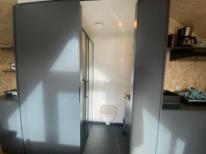 Interior view of the Solo Retreat 2 lodge at Zuiderzee, Netherlands, showing the toilet and kitchen area.