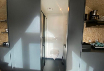 Binnenzicht van Solo Retreat 2 lodge aan het Zuiderzee in Nederland, met zicht op toilet en keuken.