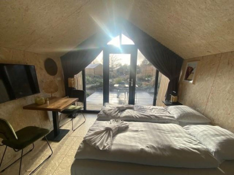 Gemütliches Zimmer im Solo Retreat 2 bei Zuiderzee, Niederlande, mit Bett und großem Fenster.