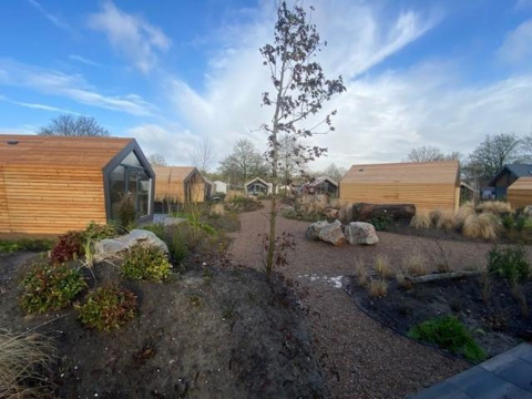 Solo Retreat 2 bij Zuiderzee in Nederland, met moderne houten lodges en een aangelegde tuin.