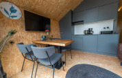 Moderne lodgeinteriør hos Solo Retreat 4 i Zuiderzee, Holland, med gråt køkken og spiseplads.