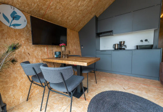 Intérieur moderne du lodge Solo Retreat 4 à Zuiderzee, Pays-Bas, avec cuisine grise et coin repas.