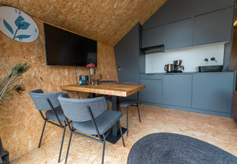 Modern interieur van Solo Retreat 4 lodge in Zuiderzee, Nederland, met grijze keuken en eetruimte.