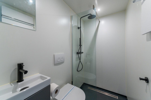 Salle de bain moderne avec douche, toilettes et lavabo au Solo Retreat 4, Zuiderzee, Pays-Bas.