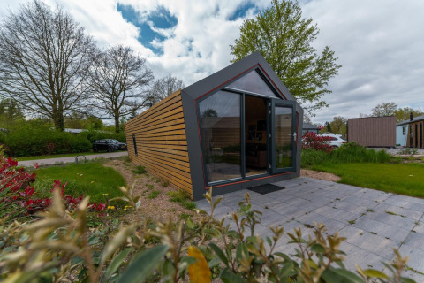 Moderne Solo Retreat 4 lodge bij Zuiderzee in Nederland met grote ramen en betegelde patio.