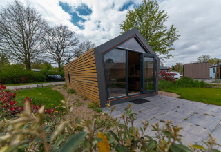 Moderne Solo Retreat 4 lodge bij Zuiderzee in Nederland met grote ramen en betegelde patio.