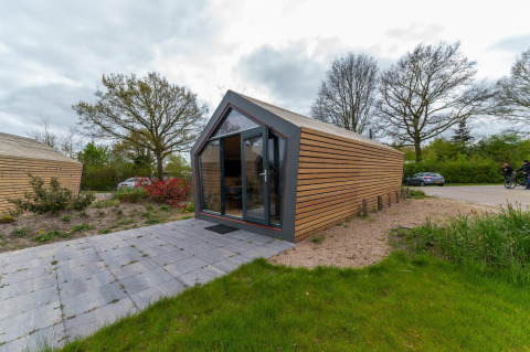 Außenansicht der Solo Retreat 4 Lodge bei Zuiderzee, Niederlande, mit moderner Holzverkleidung.