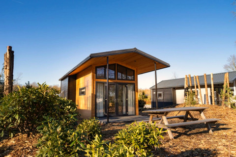 Moderne Tiny House 4-lodge ved Zuiderzee i Holland med træfacade, udendørs bord og natur omkring.