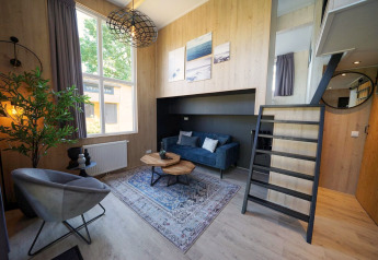 Moderna Tiny House Plus 4 allo Zuiderzee nei Paesi Bassi con soggiorno elegante e soppalco.