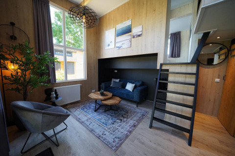 Moderne Tiny House Plus 4-lodge bij Zuiderzee, Nederland, met stijlvolle woonkamer en vide.