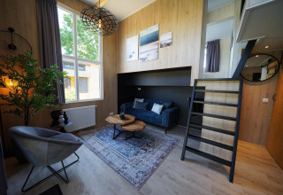 Moderne Tiny House Plus 4-lodge bij Zuiderzee, Nederland, met stijlvolle woonkamer en vide.