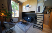 Modernes Tiny House Plus 4 bei Zuiderzee, Niederlande, mit stilvollem Wohnbereich und Hochbett.