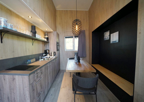 Moderne, kleine Küche und Essbereich im Tiny House Plus 4 bei Zuiderzee in den Niederlanden, Holzdekor.