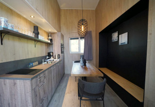 Moderne, kleine Küche und Essbereich im Tiny House Plus 4 bei Zuiderzee in den Niederlanden, Holzdekor.