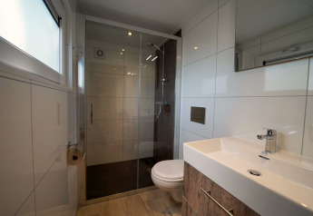 Bagno moderno con doccia e WC sospeso presso Tiny House Plus 4 a Zuiderzee, Paesi Bassi.