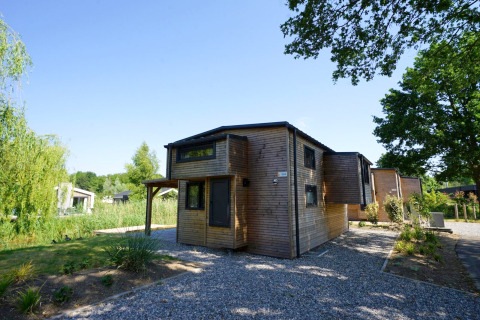 Modernes Tiny House Plus 4 Lodge aus Holz bei Zuiderzee in den Niederlanden mit grünem Garten.