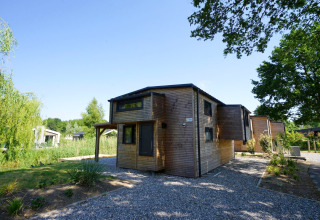 Modernes Tiny House Plus 4 Lodge aus Holz bei Zuiderzee in den Niederlanden mit grünem Garten.