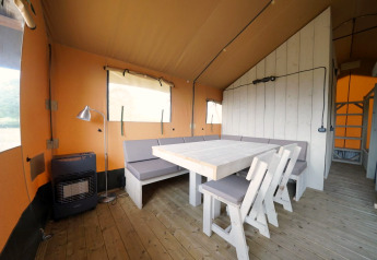 Vue intérieure de la Glampingtent 6 à Zuiderzee, Pays-Bas, avec sol en bois et salle à manger.