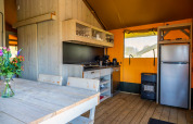 Moderne glampingtent keuken met houten interieur en eettafel bij Glampingtent 6, Zuiderzee, Nederland.