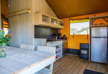 Moderne glampingteltkøkken med træinteriør og spisebord hos Glampingtent 6 i Zuiderzee, Holland.