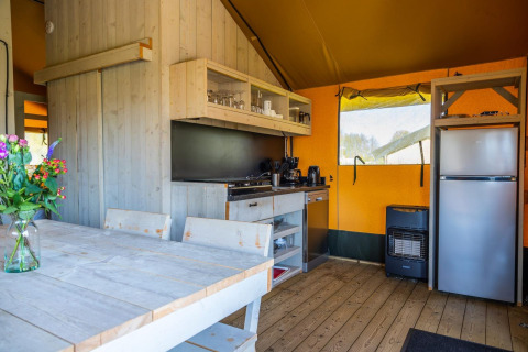 Cucina da tenda glamping moderna con interno in legno e tavolo da pranzo a Glampingtent 6, Zuiderzee, Paesi Bassi.