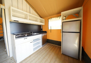 Cuisine de tente glamping moderne avec cuisinière, évier et réfrigérateur à Glampingtent 6, Zuiderzee, Pays-Bas.