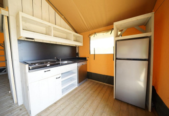 Moderne glampingtentkeuken met kookplaat, gootsteen en koelkast in Glampingtent 6, Zuiderzee, Nederland.