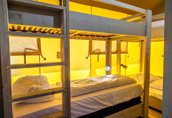 Letti a castello in una tenda glamping accogliente a Zuiderzee, Paesi Bassi, con pareti gialle.