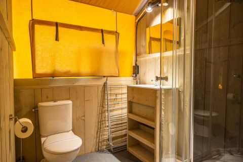 Bagno moderno con decorazioni in legno, doccia in vetro, WC e lavabo in Glampingtent 6 a Zuiderzee, Paesi Bassi.