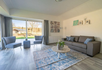 Heldere, moderne woonkamer van Velthorst 4 lodge aan Zuiderzee, Nederland, met grote ramen en zithoek.