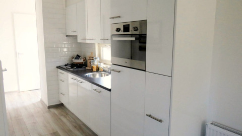 Modern white kitchen at Velthorst 4 lodge in Zuiderzee, Netherlands, featuring a built-in oven.