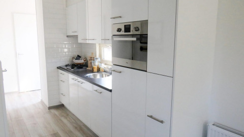 Moderna cucina bianca presso la lodge Velthorst 4 a Zuiderzee, Paesi Bassi, con forno integrato.