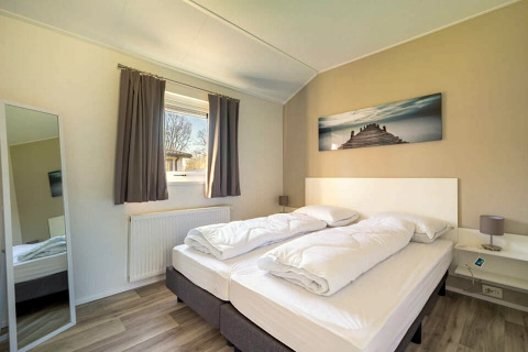 Modern bedroom inside Velthorst 4 lodge at Zuiderzee in the Netherlands, featuring bright cozy decor.