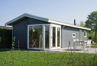 Modern Velthorst 4 lodge at Zuiderzee, Netherlands, featuring large windows and a cozy outdoor patio.