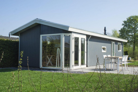 Moderno lodge Velthorst 4 a Zuiderzee, Paesi Bassi, con grandi finestre e accogliente patio esterno.