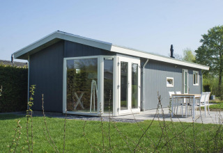 Moderno lodge Velthorst 4 a Zuiderzee, Paesi Bassi, con grandi finestre e accogliente patio esterno.