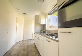 Cucina moderna con mobili bianchi, fornello a gas e finestra al Velthorst 4 presso Zuiderzee, Paesi Bassi.