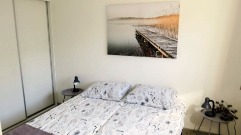 Bedroom at Velthorst 4 lodge at Zuiderzee, Netherlands, with double bed, bedside tables, and wall art.