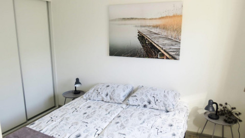 Camera da letto nella lodge Velthorst 4 a Zuiderzee, Paesi Bassi, con letto matrimoniale e tavolini.