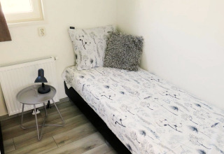 Room at Velthorst 4, Zuiderzee, Netherlands with single beds, bedside table, lamp and window.