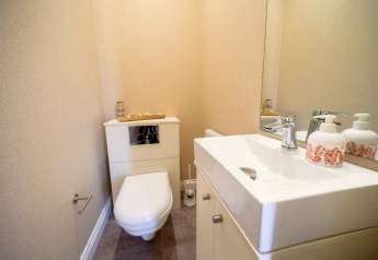 Foto di un moderno piccolo bagno in un lodge con wc sospeso, lavandino e grande specchio.